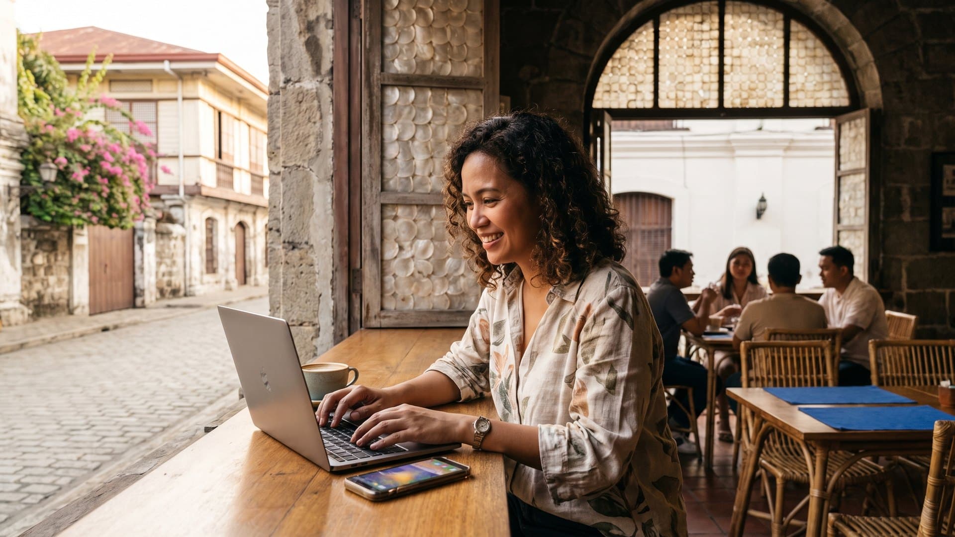 May-ari ng café sa Intramuros na nagse-set up sa laptop habang umiilaw ang kanyang telepono